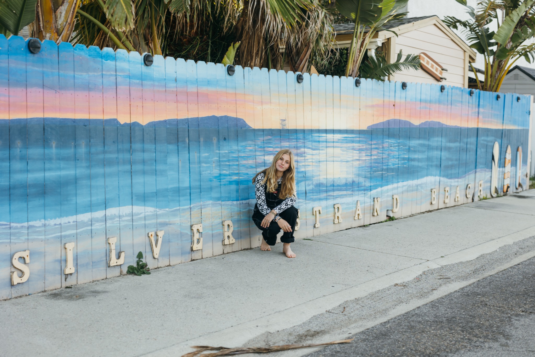 A visitor beside the colorful Silver Strand Beach mural